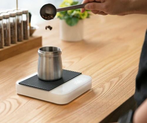 Dosage de café avec balance et pot en métal.