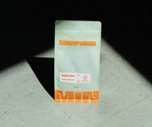 Paquet de café Minifundi sur fond ensoleillé.