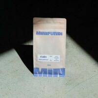 Paquet de café Minifundi sur sol en béton.