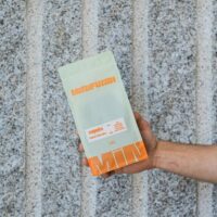 Main tenant un paquet de café Manufundi.